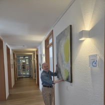 Ein Mitarbeiter hängt ein Bild auf
